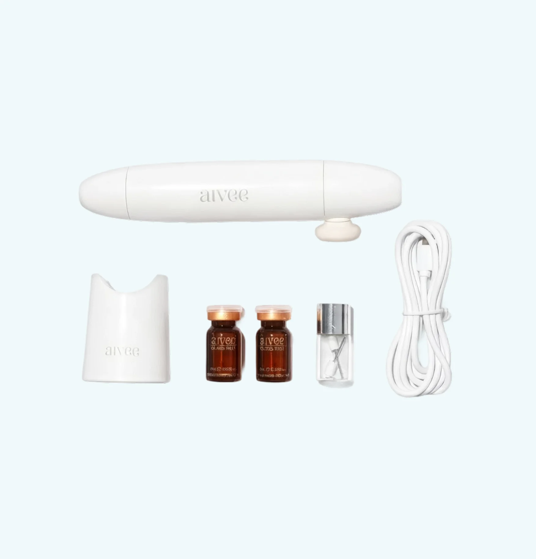 Complete set flat lay with device, cap, ampoules, and charging cable